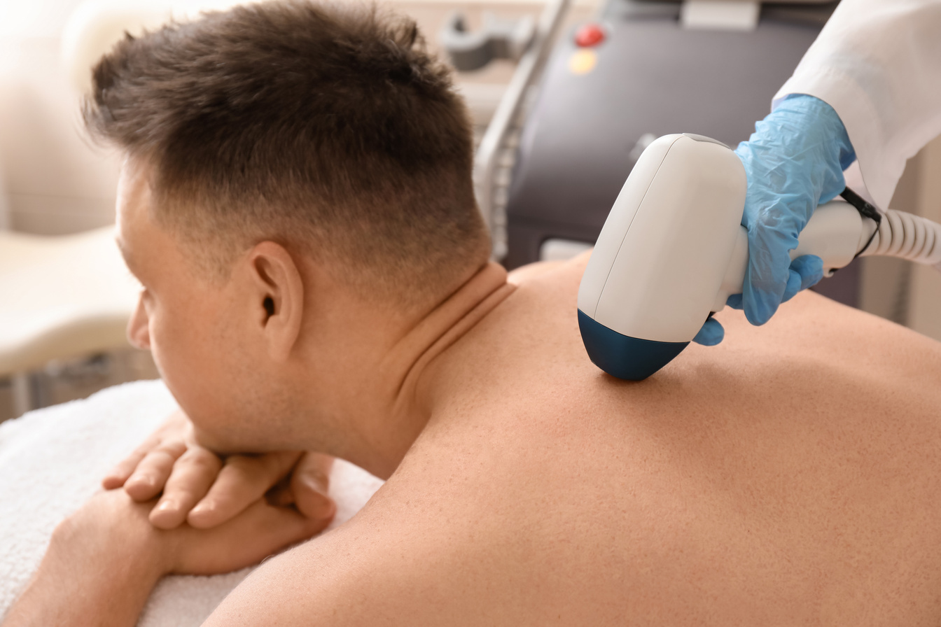 Handsome Man Undergoing Procedure of Laser Hair Removing in Beauty Salon