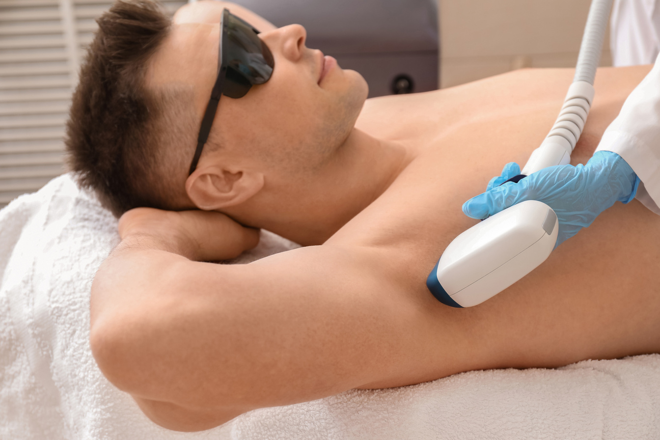 Handsome Man Undergoing Procedure of Laser Hair Removing in Beauty Salon