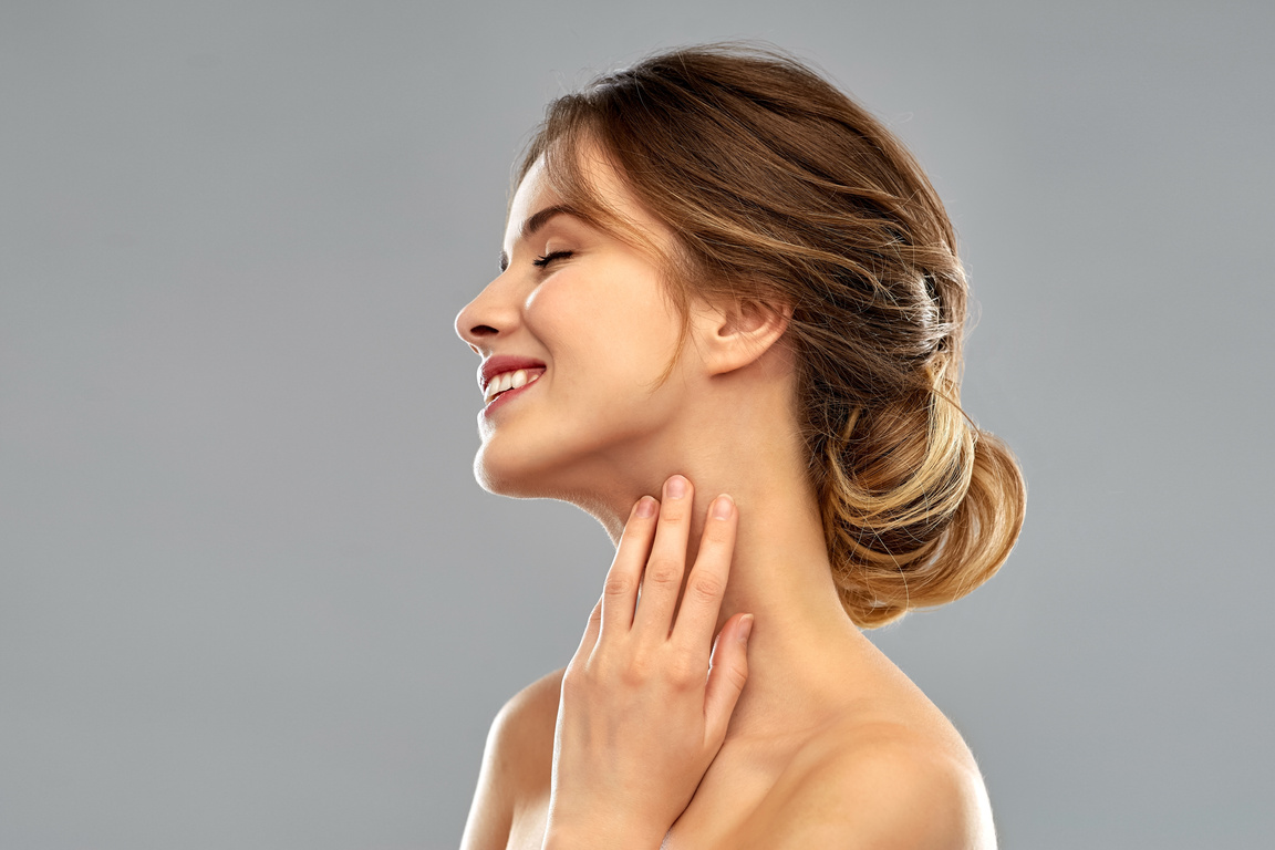 Smiling Young Woman Touching Her Neck