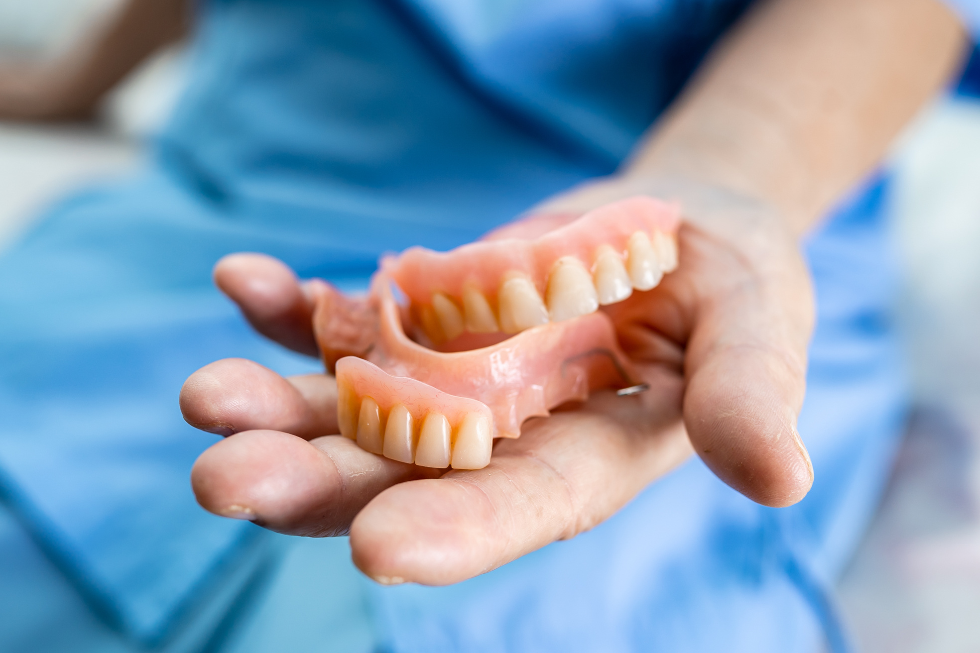 Elderly Patient Holding Dentures